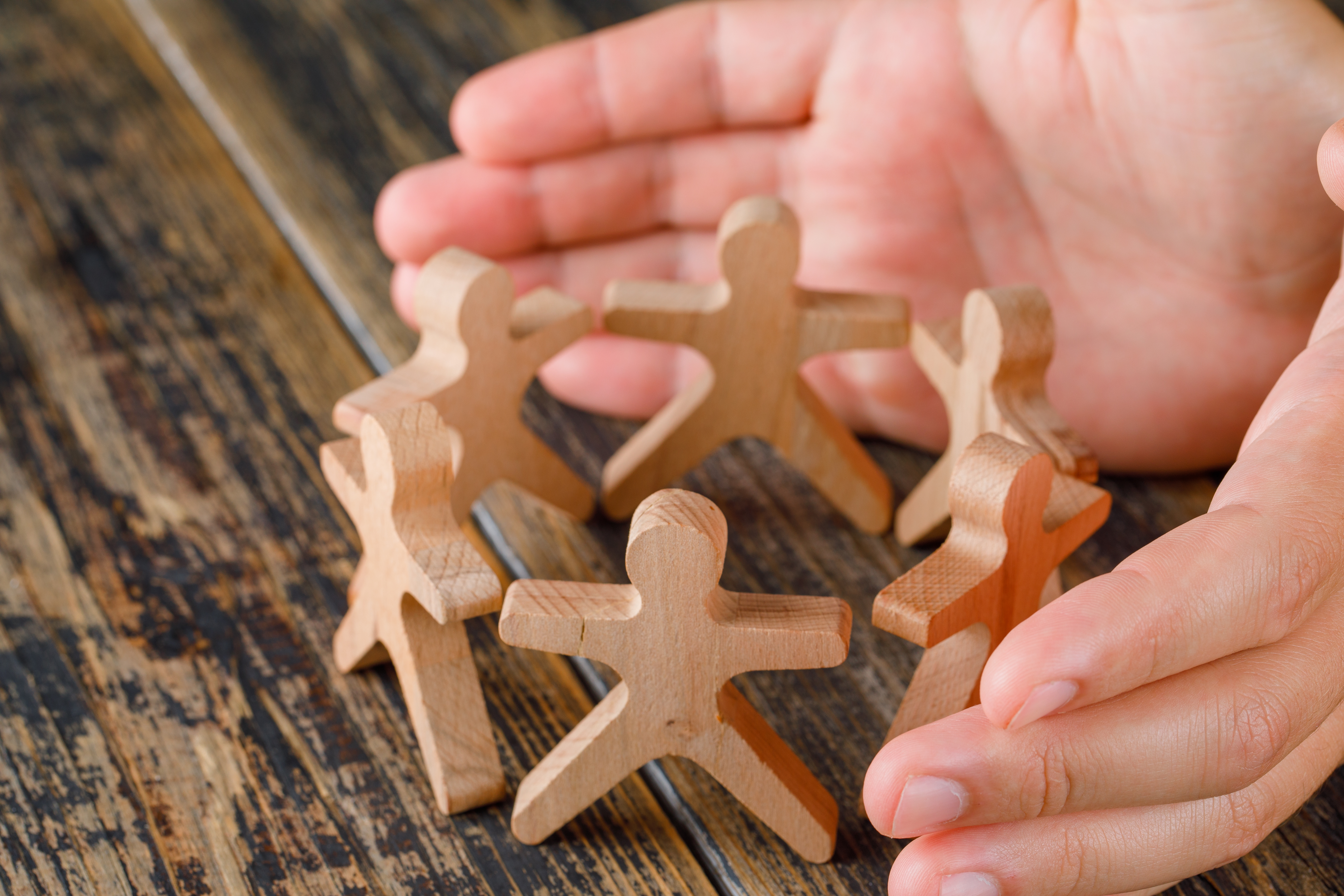 <a href="https://www.magnific.com/free-photo/business-success-concept-wooden-table-top-view-hands-protecting-wooden-figures-people_9426579.htm">Image by 8photo on Magnific</a>
